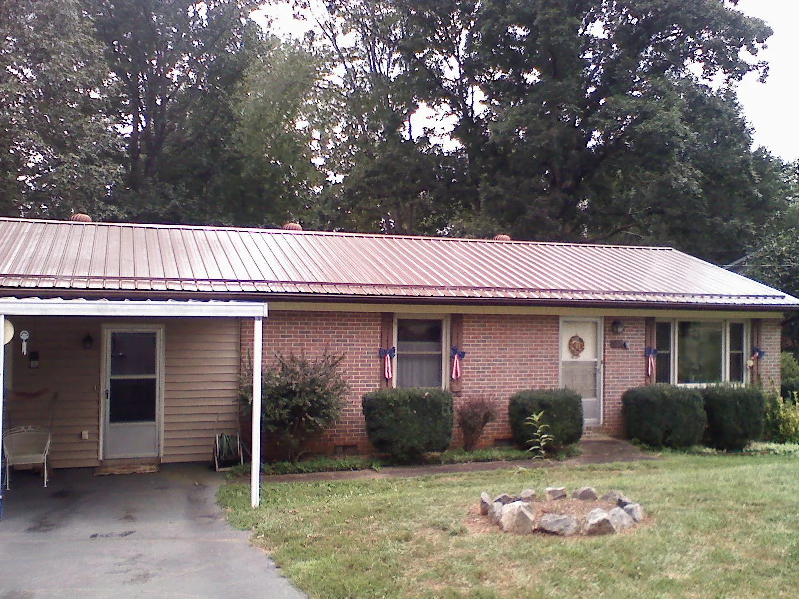 Bronze metal roof and carport on a brick ranch home — Roof Repair work by our crew in Hamler